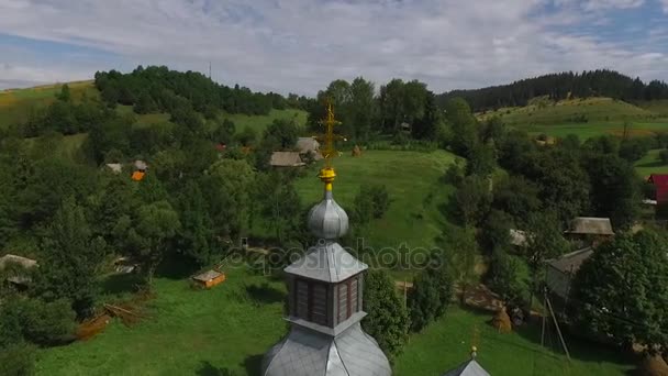 La cima de la cúpula de la iglesia en el fondo de un pueblo de montaña . — Vídeos de Stock