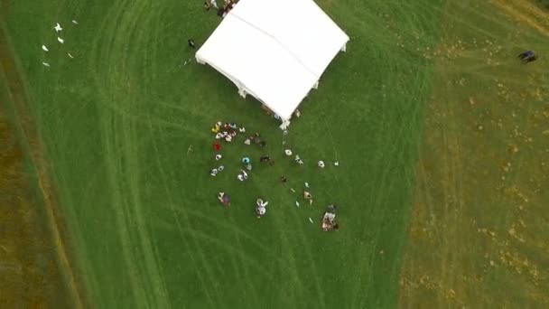 人们站在白色帐篷附近的空地上. — 图库视频影像