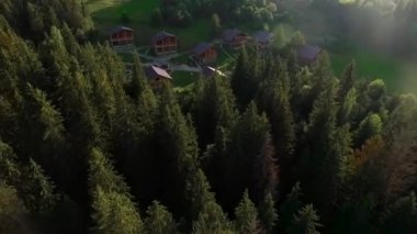 Orman ve dağlar ortasında yazlık köyden uzakta dron taşır.