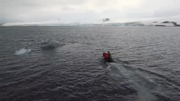 Um barco com pessoas a flutuar à volta de pedaços de um iceberg. Andreev . — Vídeo de Stock