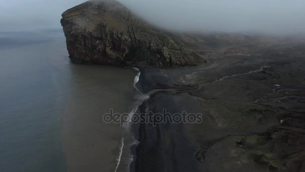 Una vista del acantilado y la playa negra con las olas que permanecen. Andreev. . — Vídeo de stock