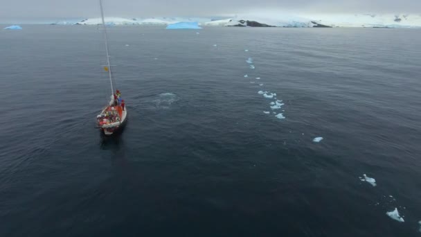 A piros hajó vitorlák darab jég mentén a partra. Andrejev. — Stock videók
