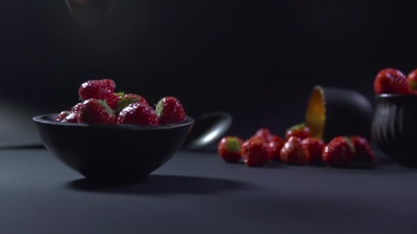 Fresas caen en un tazón negro . — Vídeos de Stock