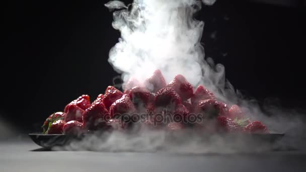 Der Dampf von flüssigem Stickstoff wird auf einen Teller mit Erdbeeren gegossen. — Stockvideo