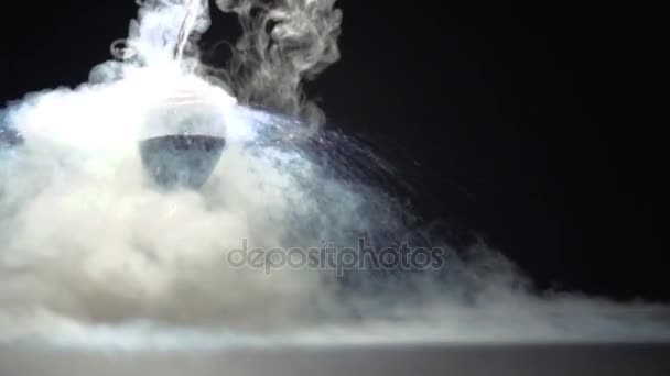 Een stroom van vloeibare stikstof giet op de zandloper glas. — Stockvideo