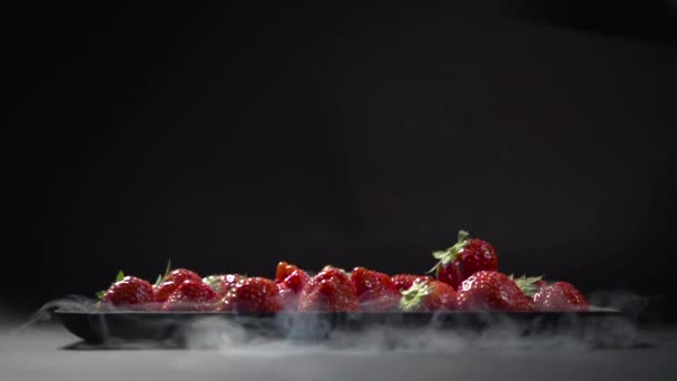 Jahody leží na talíři v kouři kapalného dusíku. — Stock video