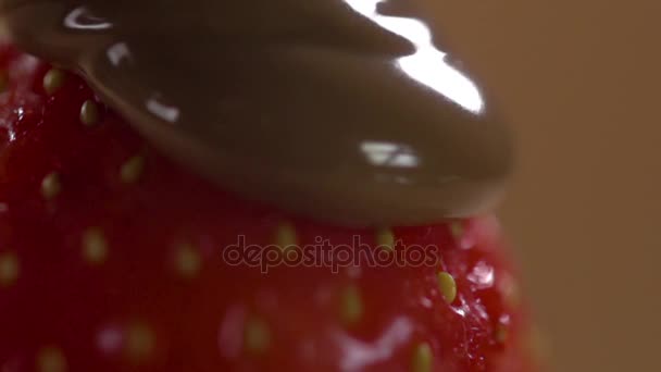 Close-up de chocolate líquido que flui sobre um morango . — Vídeo de Stock