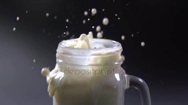 Galletas de almendras caen en una taza con leche . — Vídeo de stock