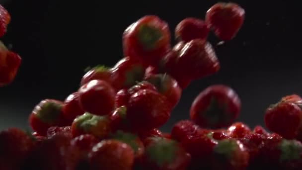 Φράουλες πέφτουν από την πλευρά της επιφάνειας με μούρα. — Αρχείο Βίντεο