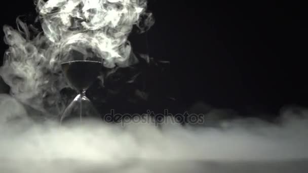 Smoke dissolves in the air around the hourglass. — Stock Video