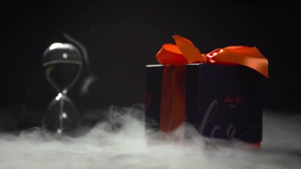 Coffret cadeau noir sur fond sablier . — Video