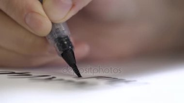 Fırça beyaz kağıt üzerinde hareket eder ve harfler çizer.