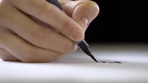 La mano sostiene un bolígrafo con un cepillo en el extremo y escribe . — Vídeo de stock