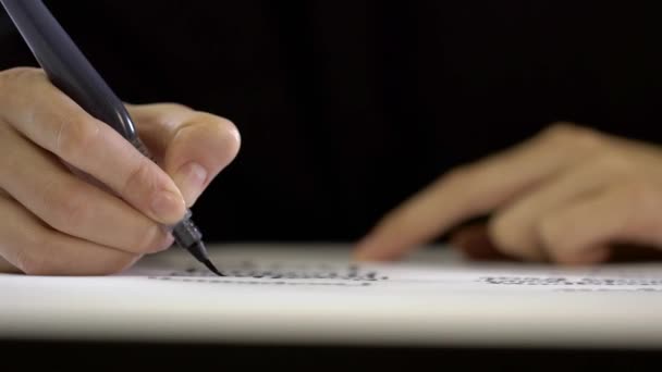 Female hands write with a brush words on white paper. — Stock Video