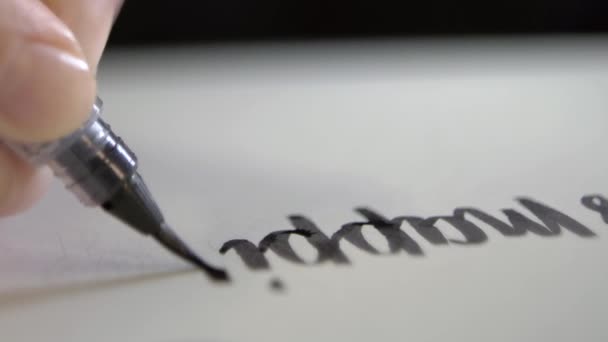 A mão desenha palavras com um pincel com tinta . — Vídeo de Stock