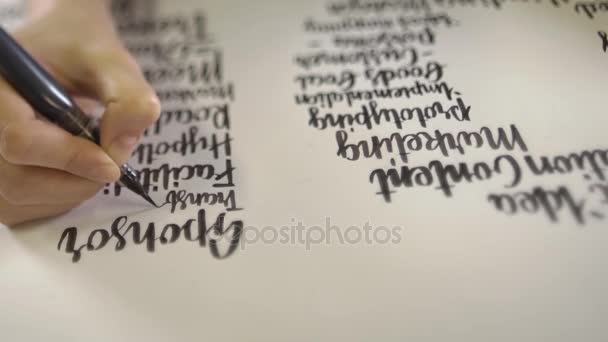 Рука записує каліграфічне слово у колонці . — стокове відео