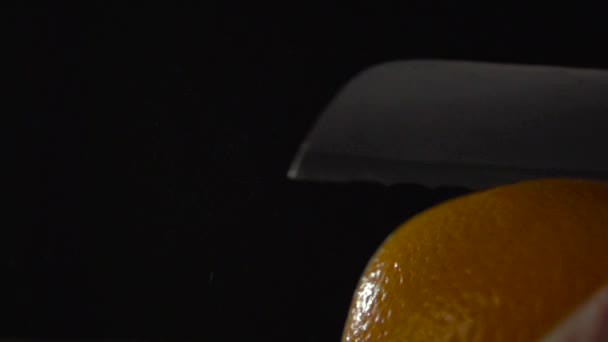 Bladet på kniven skär skalet av apelsinen. — Stockvideo