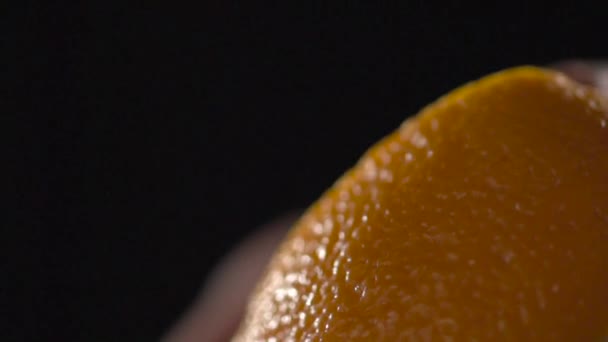 The hand removes the peel from the orange. — Stock Video