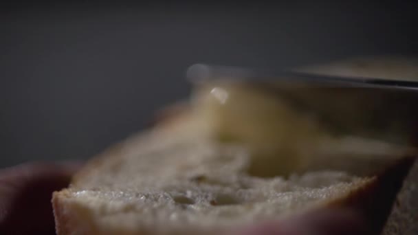 Ніж розкладає масло на шматку хліба . — стокове відео
