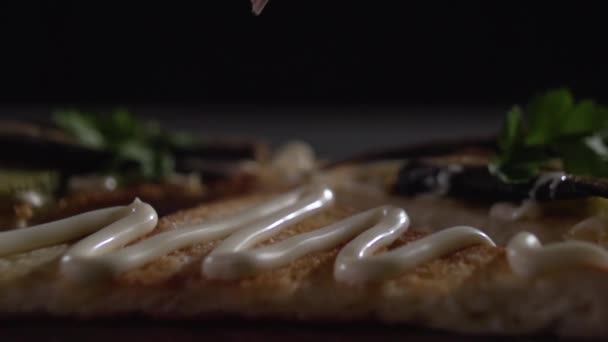 Las manos ponen dos espadines pequeños sobre la mayonesa sobre la tostada . — Vídeos de Stock