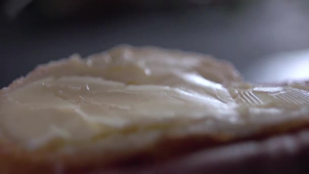 Yavaş yavaş bir bıçak tereyağı ekmek üzerinde yayılan ateş. — Stok video