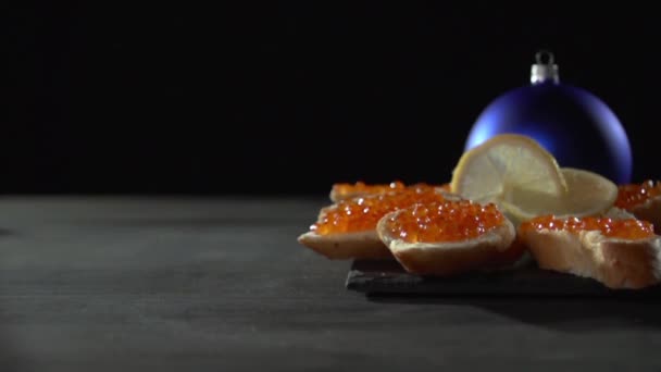 Una mano de hombre levanta un sándwich con caviar rojo . — Vídeo de stock