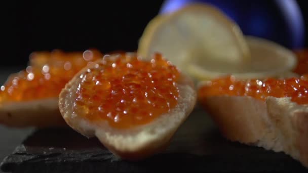 Nahaufnahme von rotem Kaviar auf Brot mit Butter. — Stockvideo