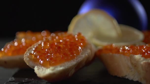 Uitzicht op een kleine sandwich met rode kaviaar. — Stockvideo