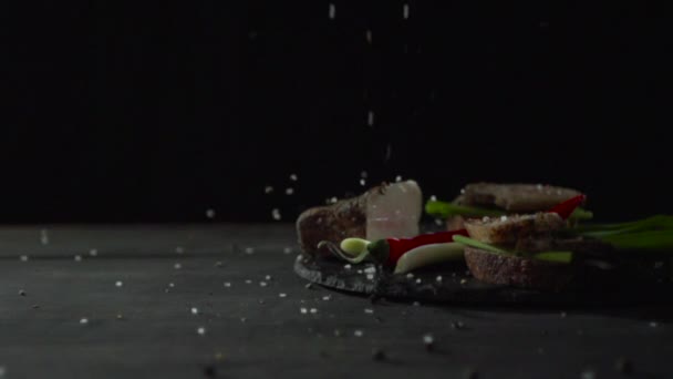 Uma mão chega para um sanduíche com pão preto com bacon e cebola . — Vídeo de Stock