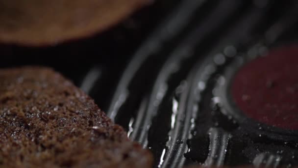 Um close-up de um pedaço de pão caindo em uma frigideira com nervuras . — Vídeo de Stock