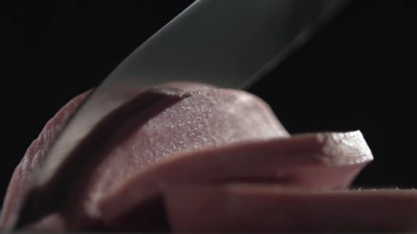 Le couteau coupe la saucisse sur une surface grise .