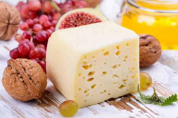 Ladrillo de queso amarillo con especias y aperitivos — Foto de Stock