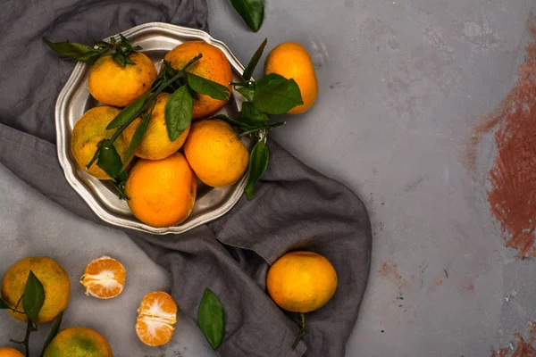 Mandariner med blad på stenbord. Ovanifrån — Stockfoto