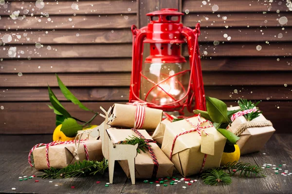 Mnoho zdobené vánoční dárky a staré vintage olejovou lampu na dřevěné pozadí — Stock fotografie