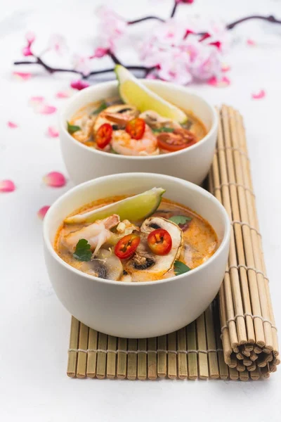 Традиційні Tom Yum суп з квітучими Сакура відділення на Білий камінь таблиці — стокове фото