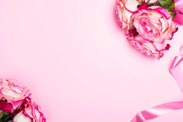 Krásné růžové růže, dekorativní konfety srdce a růžová stuha na růžovém pozadí Valentýn — Stock fotografie