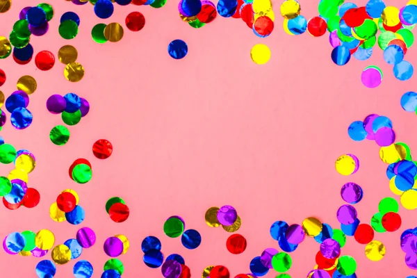 Confete colorido sobre fundo rosa — Fotografia de Stock
