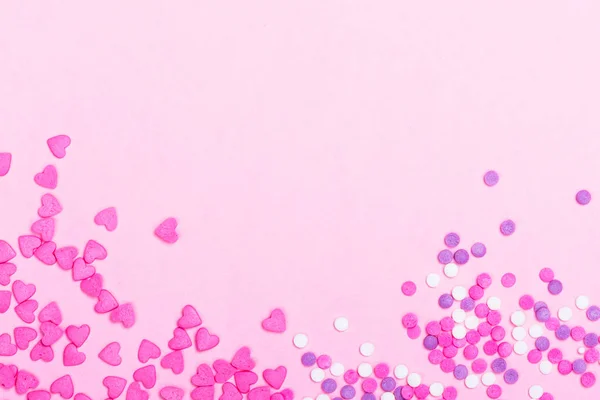 Pink heart shaped sprinkles on pink Valentines day background — Stock Photo, Image