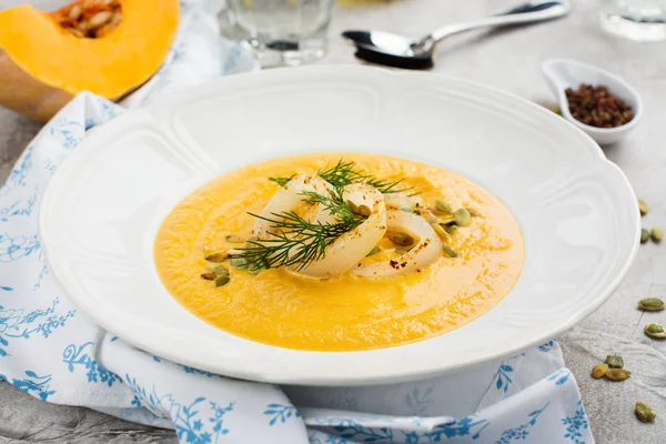 Homemade pumpkin and carrot soup with squid rings, seeds and dill — Stock Photo, Image