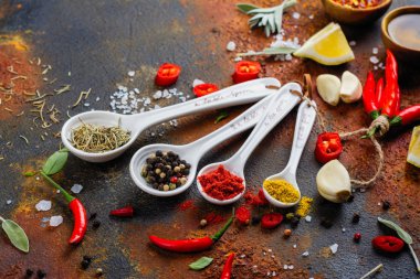 Kuru otlar ve baharatlar beyaz taş mutfak masasında ölçme kaşık içinde