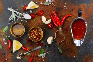 Baharatlı domates sosu ve siyah arka plan üzerine malzemeler