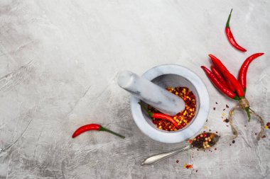 Sıcak kırmızı pul biber mermer bir harç ve karabiber taş masada