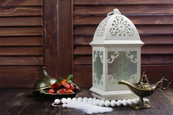 Arabic lantern, dates, aladdin lamp and rosary on wooden background — Stock Photo, Image