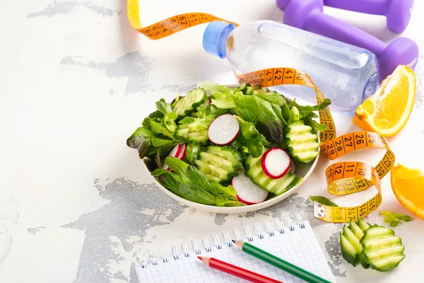 Ensalada vegetariana saludable, pesas y botella de agua en la mesa de madera — Foto de Stock