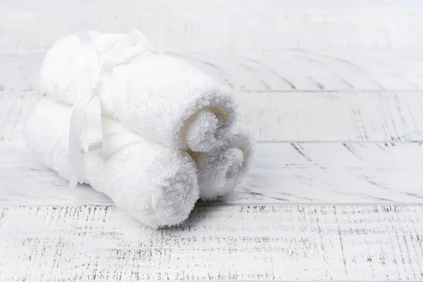 White cotton towels and branch of cotton on wooden table — Stock Photo, Image