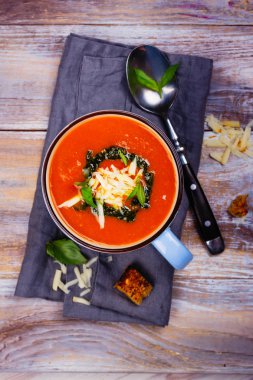 Seramik bir fincan pesto sos ve parmesan peynirli domates çorbası