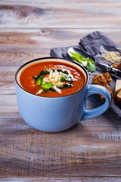 Sopa de tomate com molho pesto e queijo parmesão em uma xícara de cerâmica — Fotografia de Stock