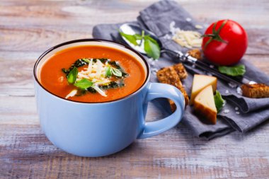 Seramik bir fincan pesto sos ve parmesan peynirli domates çorbası