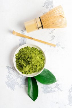 Beyaz zemin üzerine yeşil matcha çay toz ve çay aksesuarları
