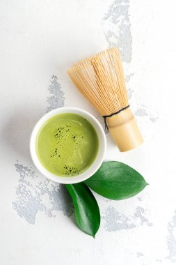 Beyaz zemin üzerine yeşil matcha çay içecek ve çay aksesuarları